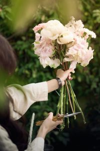 Fleuriste recoupant les tiges d'un bouquet en biseau